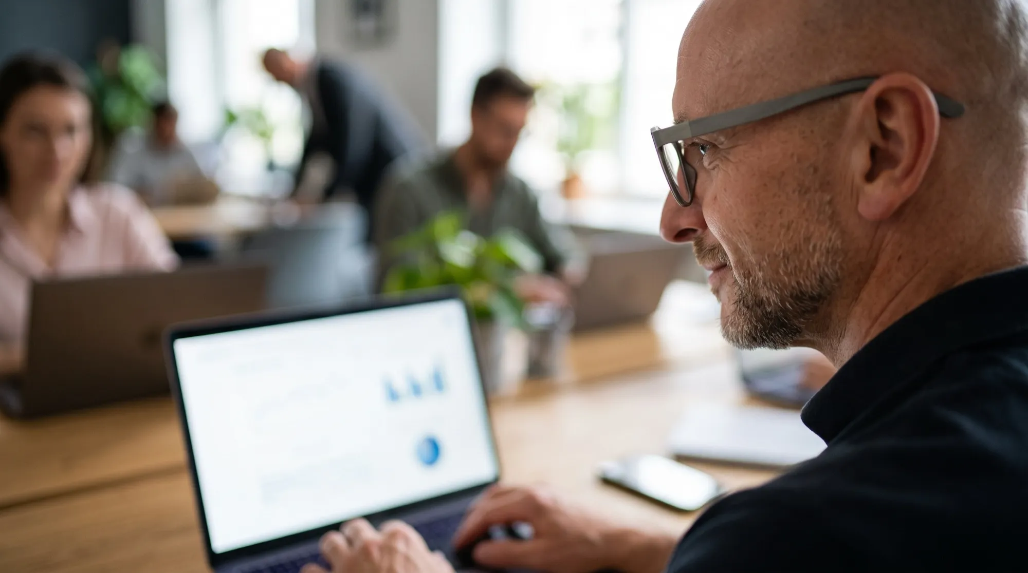 Unternehmer prüft die Auswertung seiner Marketing-Kampagnen am Laptop